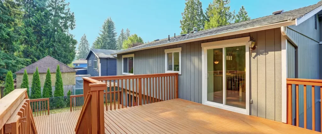 Wooden backyard deck attached to a single-story home.