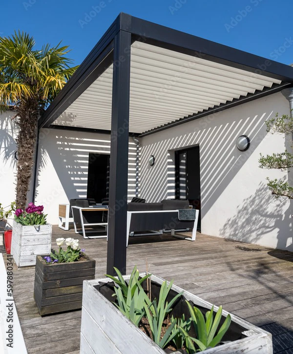 A luxury cedar wood pergola built by expert pergola builders in Carmel, IN, featuring a full outdoor kitchen, stone fireplace, and dining area.