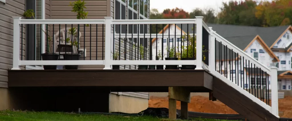 a deck railing system featuring black metal balusters and white posts