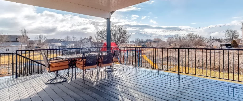 a modern covered deck with composite flooring and black aluminum railings